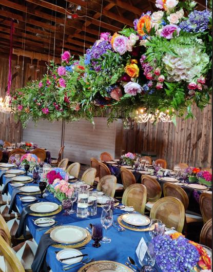 Colorful suspended floral installation above an elegant banquet table
