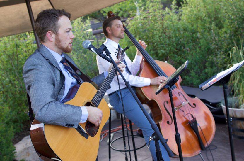 A live acoustic duo performing with guitar and upright bass at an outdoor Utah event