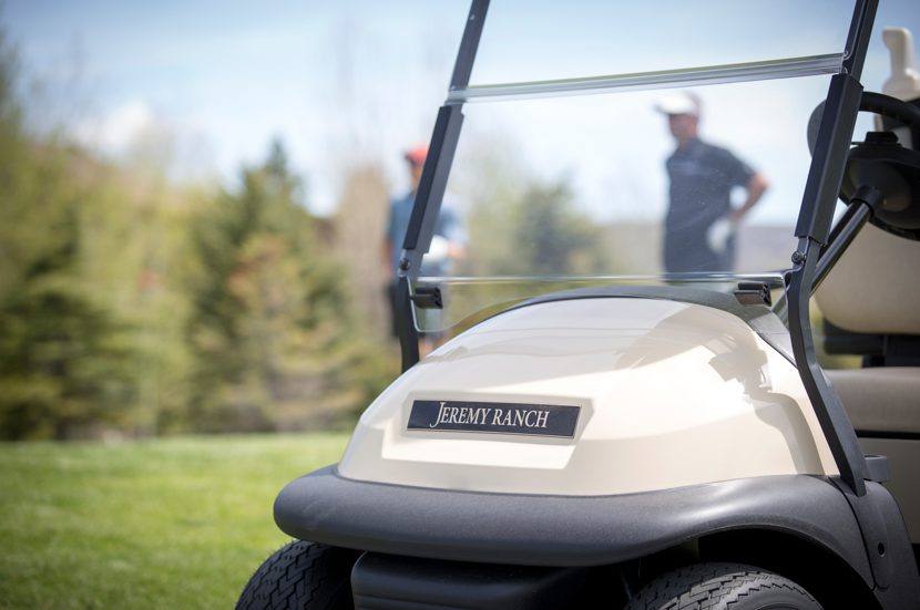 A Jeremy Ranch golf cart on the course with golfers in the background