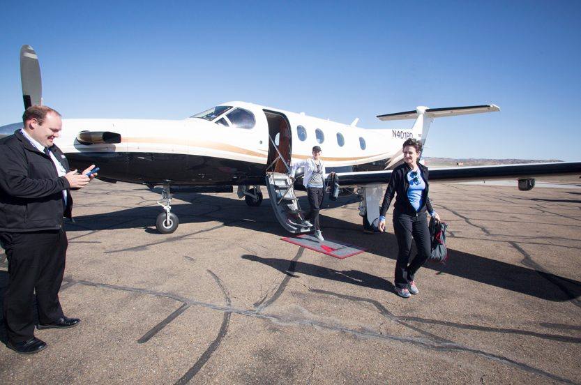 VIP guests deplaning a private jet on a sunny Utah tarmac