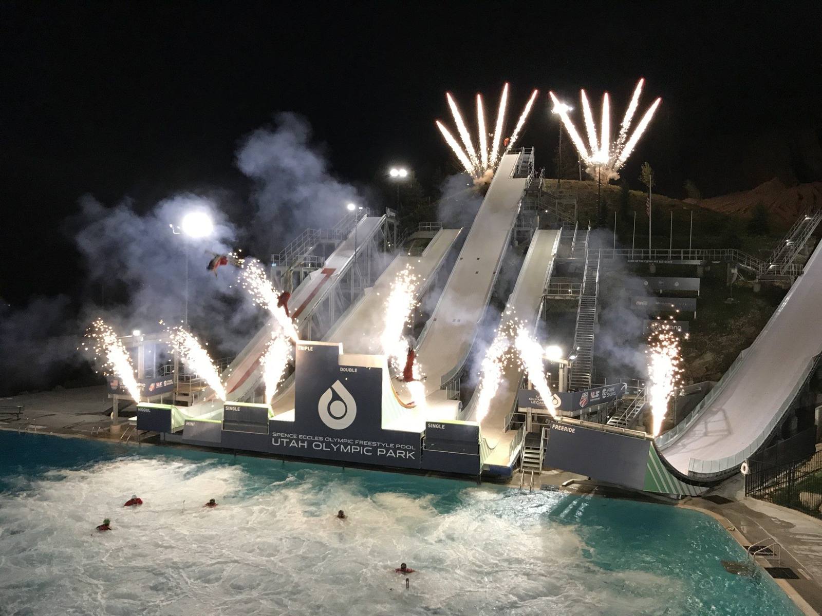 Spence Eccles Olympic Freestyle Pool at Utah Olympic Park at night with aerial performers and fireworks over the ski ramps
